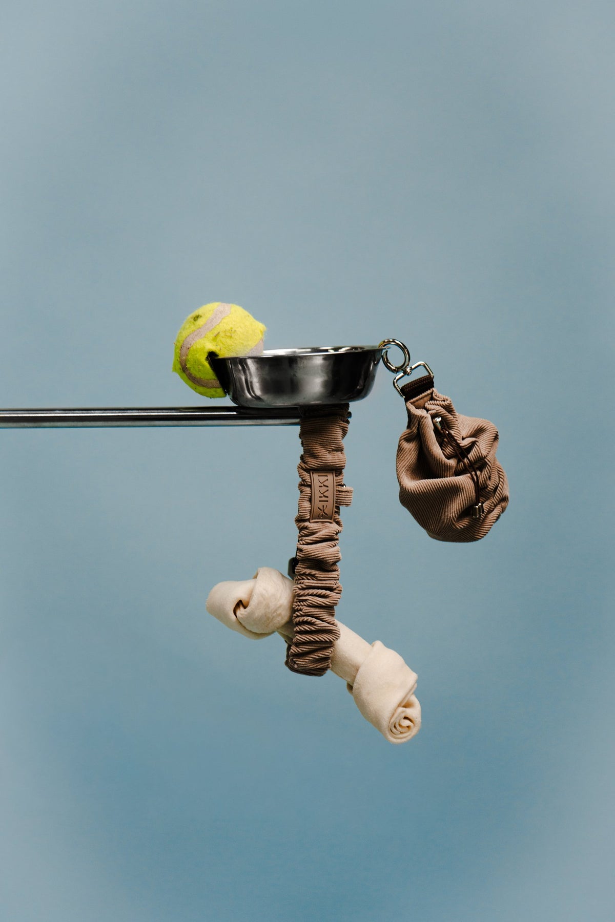 Noah pouch in Coffee with a ball, bowl and leash, still life